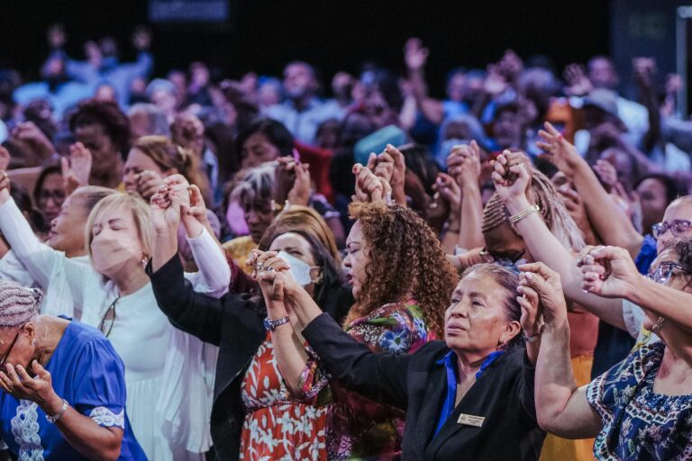 A diverse group of people in a heartfelt spiritual gathering, holding hands in unity.